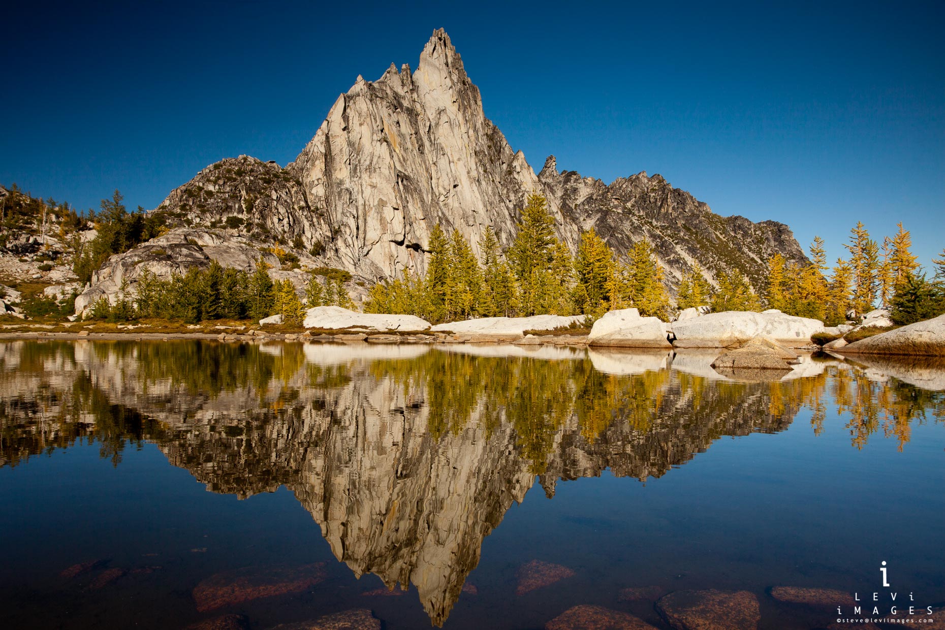 Prusik Peak and Larch trees reflected in alpine lake on a fall afternoon, the Enchantments, Washington, USA