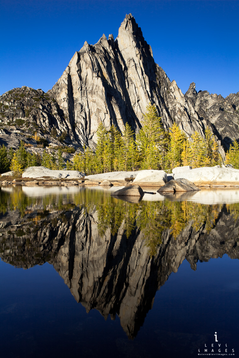 Prusik Peak and Larch trees reflected in alpine lake on a fall afternoon, the Enchantments, Washington, USA