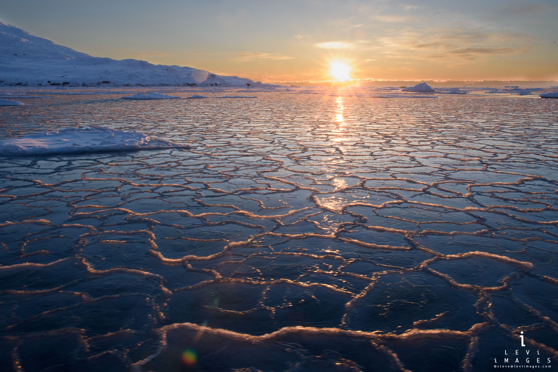 Sunset over honeycomb ice in fjord. Svalbard, Norway