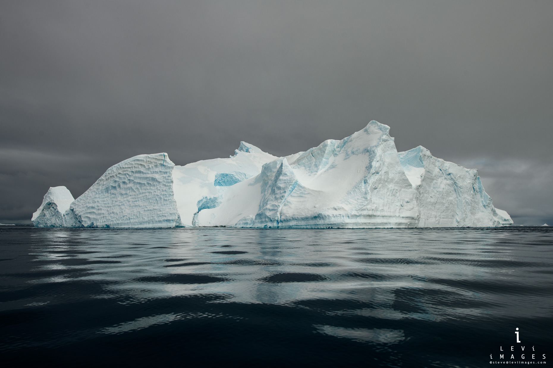Icerberg reflected in dark sea. Antarctica